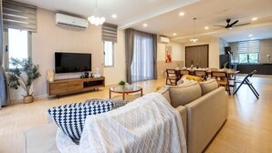 Un salon moderne avec un canapé, un téléviseur et un coin repas.