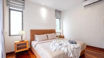 Una camera da letto con un letto, comodini e un condizionatore d'aria.