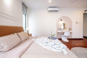 Un dormitorio con cama, mesita de noche, lámpara y un arco que da a un baño.