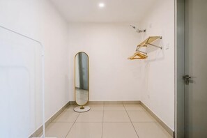 A small, empty bathroom with a round mirror, a towel rack, and a door. - LAKE VILLA BY FEEL HOME (Putrajaya)