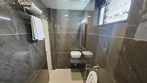 Un baño moderno con inodoro, dos lavamanos y ducha.