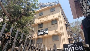 Un edificio de varios pisos con un cartel que dice "HOTEL TRITON".