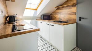 Une cuisine moderne dotée d’une lucarne, d’un four à micro-ondes, d’une bouilloire et d’un évier.