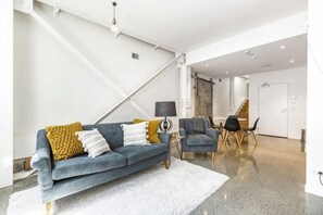 Una sala de estar moderna con sofá, mesa de centro y sillas.