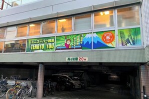 Un bâtiment portant une enseigne publicitaire pour « Tenyuu You » et dont la hauteur maximale est de 20 mètres.