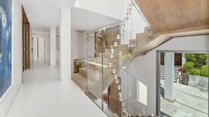 Ein modernes Interieur mit einer Glasstufenhaus, einer hohen Decke und Blick ins Freie.