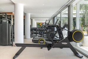 A gym with exercise equipment, large windows, and a modern interior design. - All About Villa Serenity (Marbella)