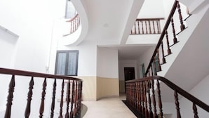 A spacious interior with a curved staircase, a large window, and a door. - Phu Gia 113 Nguyen Thi Thap (Ho Chi Minh City)