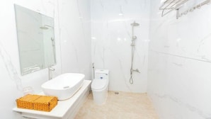 A small, modern bathroom with a white sink, toilet, and shower. - Phu Gia 113 Nguyen Thi Thap (Ho Chi Minh City)