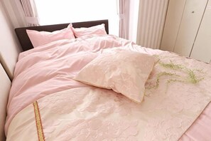 A bed with a headboard, pillows, and a blanket. - Du Etowaru #801 (Nagoya)