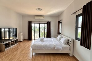 A bedroom with a bed, a TV, a heater, and a window with curtains. - Elly's Home. Convenience & Serenity (Chiang Mai)