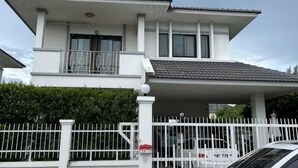 A two-story house with a balcony, a gated driveway, and a car parked in front. - Elly's Home. Convenience & Serenity (Chiang Mai)