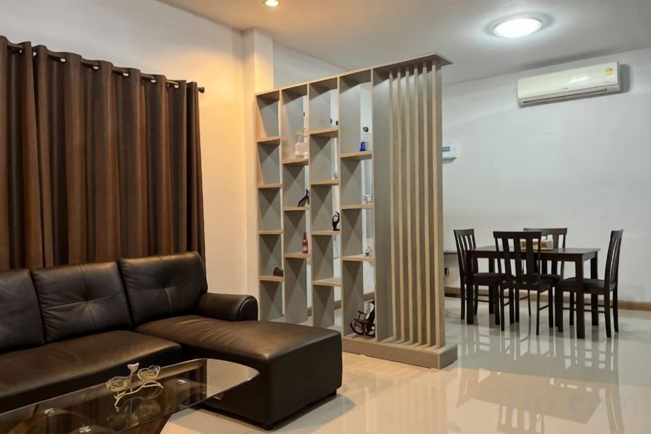 Una sala de estar moderna con un sofá, una mesa de centro y un comedor con sillas y una mesa.