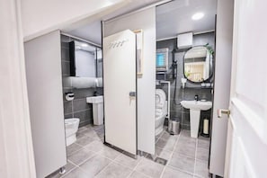 A modern bathroom with a toilet, sink, and mirror. - JT_TEVA (USD) (Seoul)
