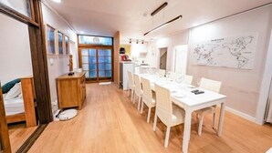 A modern kitchen with white cabinets, a dining table with chairs, and a large map on the wall. - JT_TEVA (USD) (Seoul)
