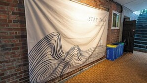 A banner with 'STAY' text, a brick wall, a window, and a door. - JT_TEVA (USD) (Seoul)