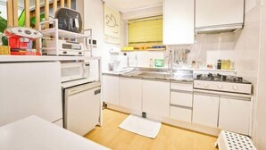 A compact kitchen with white cabinets, a stove, a sink, and a microwave. - JT_TEVA (USD) (Seoul)