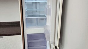 Un réfrigérateur ouvert, doté de plusieurs étagères et d’un compartiment congélateur.