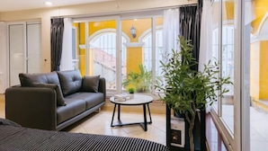 A modern living room with a sofa, a coffee table, and a potted plant. - VietHOME - 22 Pho Hue - Duplex 602 (Hanoi)