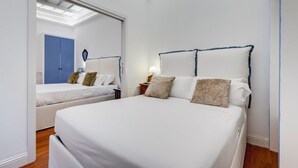 A hotel room with a large bed, a smaller bed, a wardrobe, and a skylight. - Babuino 55 - FromHometoRome (Roma)