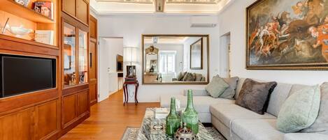 A living room with a wooden bookshelf, a large painting, and a sofa.