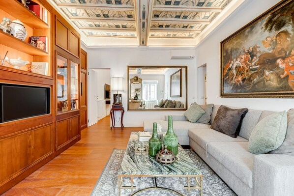 A living room with a wooden bookshelf, a large painting, and a sofa.