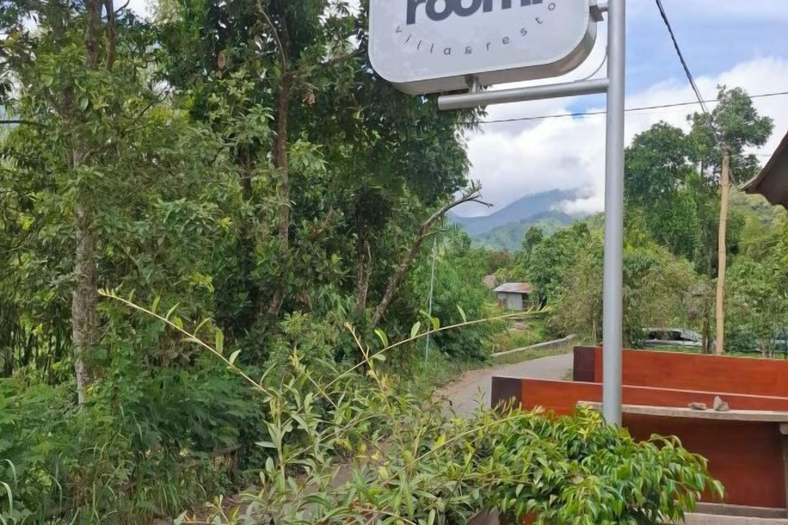 A sign for a hostel with a view of a mountainous landscape.