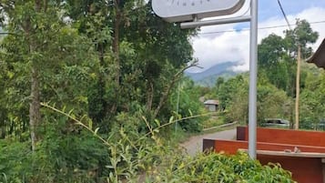 A sign for a hostel with a view of a mountainous landscape.