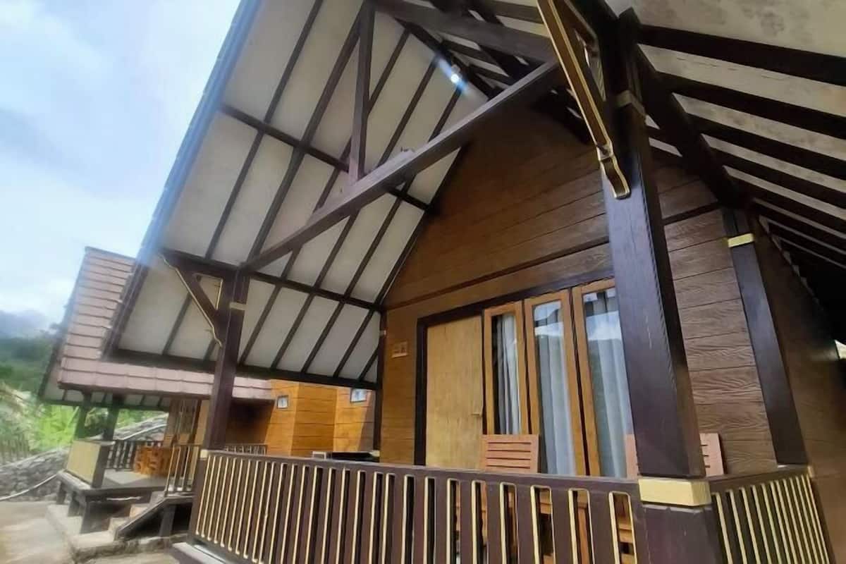 Un bâtiment en bois doté d’un toit en pente et d’un balcon avec une balustrade.
