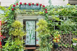 A traditional Japanese garden entrance with a wooden gate, bamboo plants, and a sign for the Tokyo Yushiba Garden Hotel. - Tokyo Yoshihisa Garden Hotel. Whole building for rent (Tokyo)