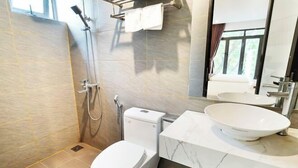 Et moderne badeværelse med toilet, bidet og stor vask.