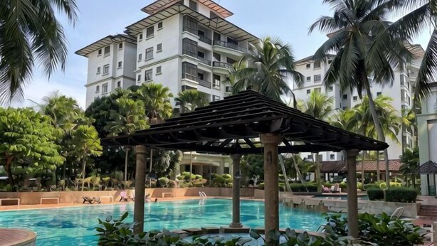 Area piscina con una pergola, palme e un edificio a più piani sullo sfondo.