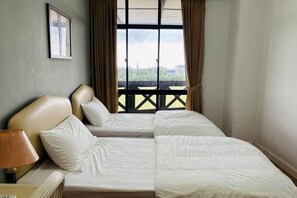 A hotel room with two beds, a window with curtains, a lamp, and a framed picture on the wall. - Heart of City Seaside view Mahkota Costa (Melaka)