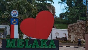 Un cartello con la scritta 'MELAKA' e un grande cuore rosso.