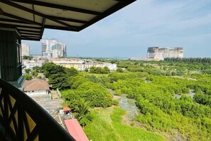 Blick vom Balkon auf einen Fluss, Gebäude und Grünflächen.