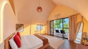 A spacious tent-style room with a large bed, a dining area, and a view of the outdoors. - Lu Ying Retreats (Bentong)