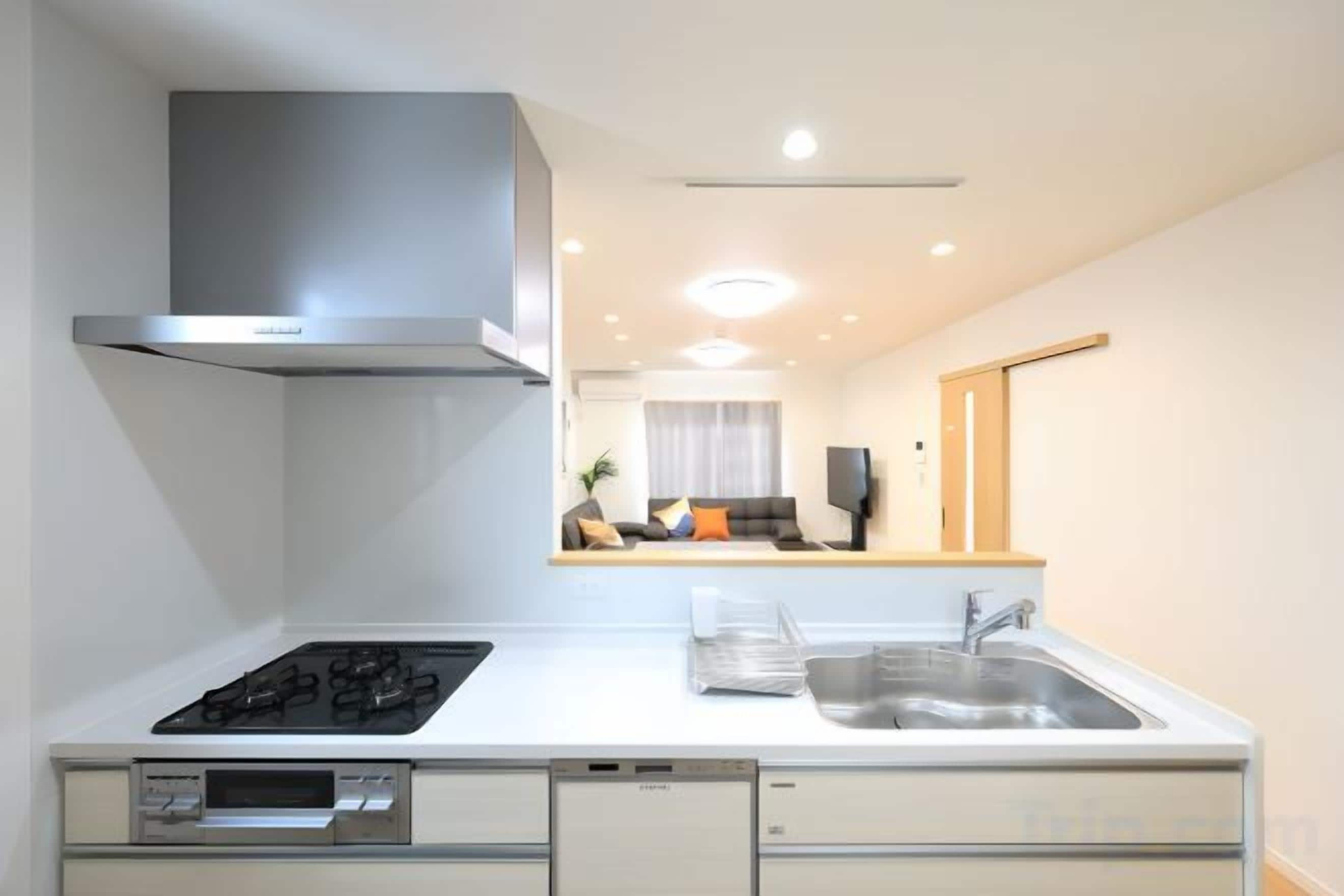 A modern kitchen with a stove, sink, and built-in oven.