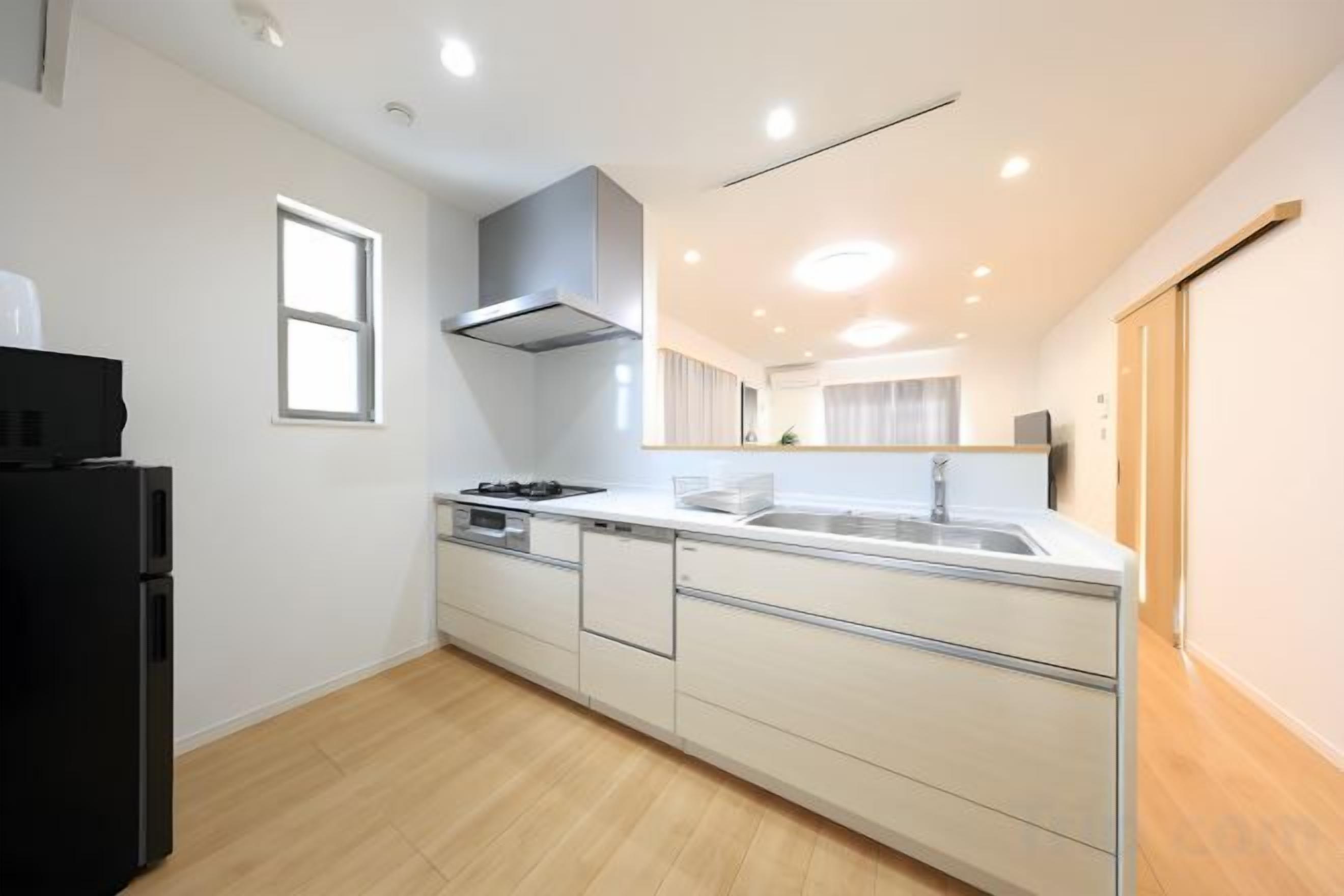 A modern kitchen with a stove, sink, and cabinets.