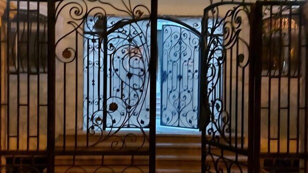 A wrought iron gate with intricate designs, leading to a wooden staircase. - Jamila Residential Apartment (Cairo)