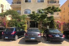 A multi-story residential building with parked cars in the foreground. - Jamila Residential Apartment (Cairo)