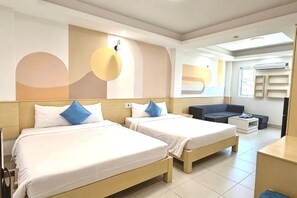 A hotel room with two beds, a sofa, a desk, and a large window. - Sea Charm Hotel (Da Nang)