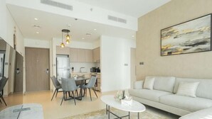 Una sala de estar moderna con un sofá, una mesa de centro y un comedor con sillas.