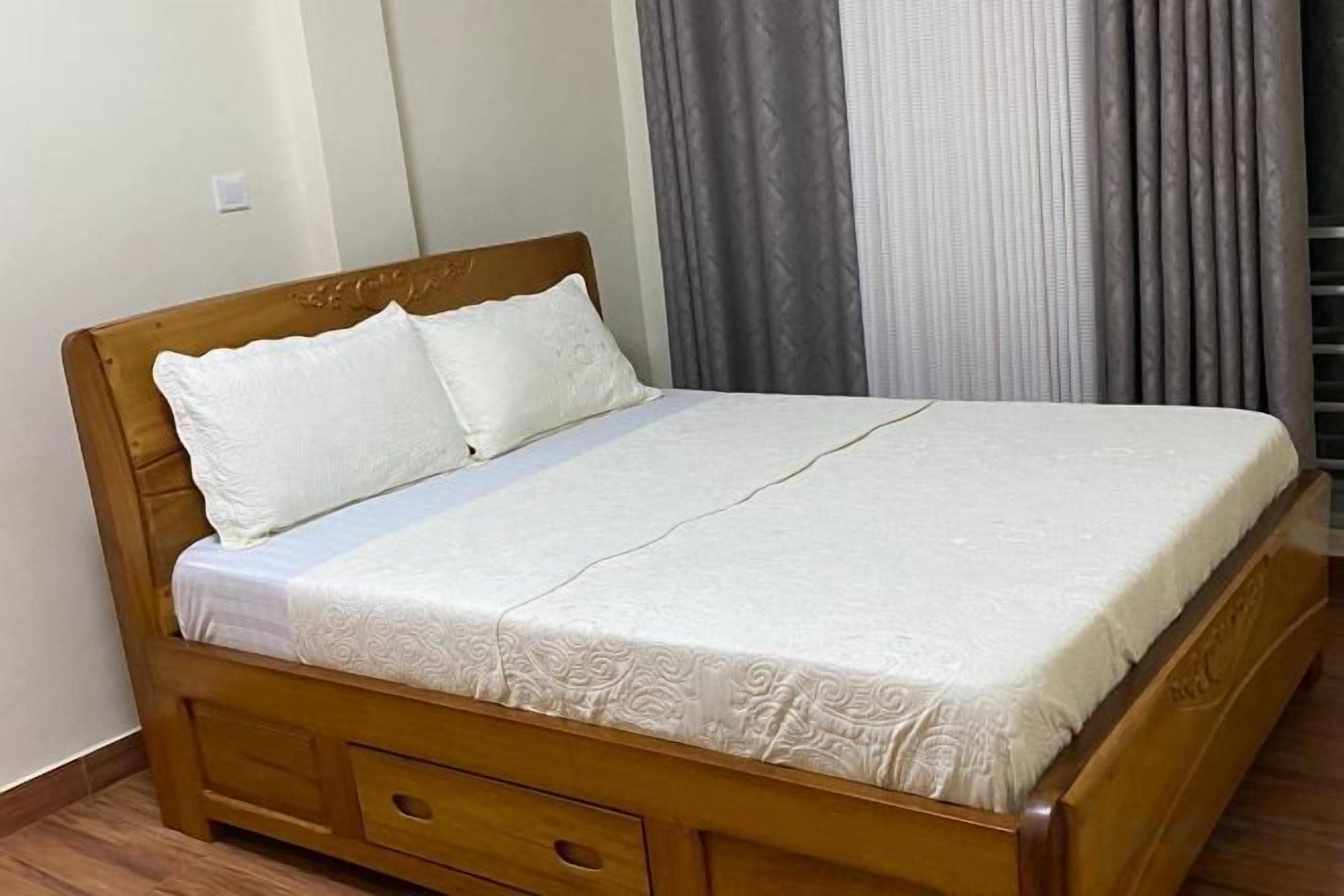 A single bed with a wooden frame and a white mattress.