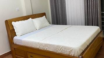 A single bed with a wooden frame and a white mattress.