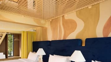 A hotel room with two beds, a large window, and a unique ceiling design.