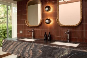 A bathroom with two sinks, a large mirror, and a wall-mounted light fixture. - Mahi-Mahi Beachfront Villa by Yudee Assets (Tha Yang)