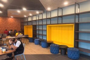 Een modern interieur met zitgedeeltes, tafels en een bakstenen muur.