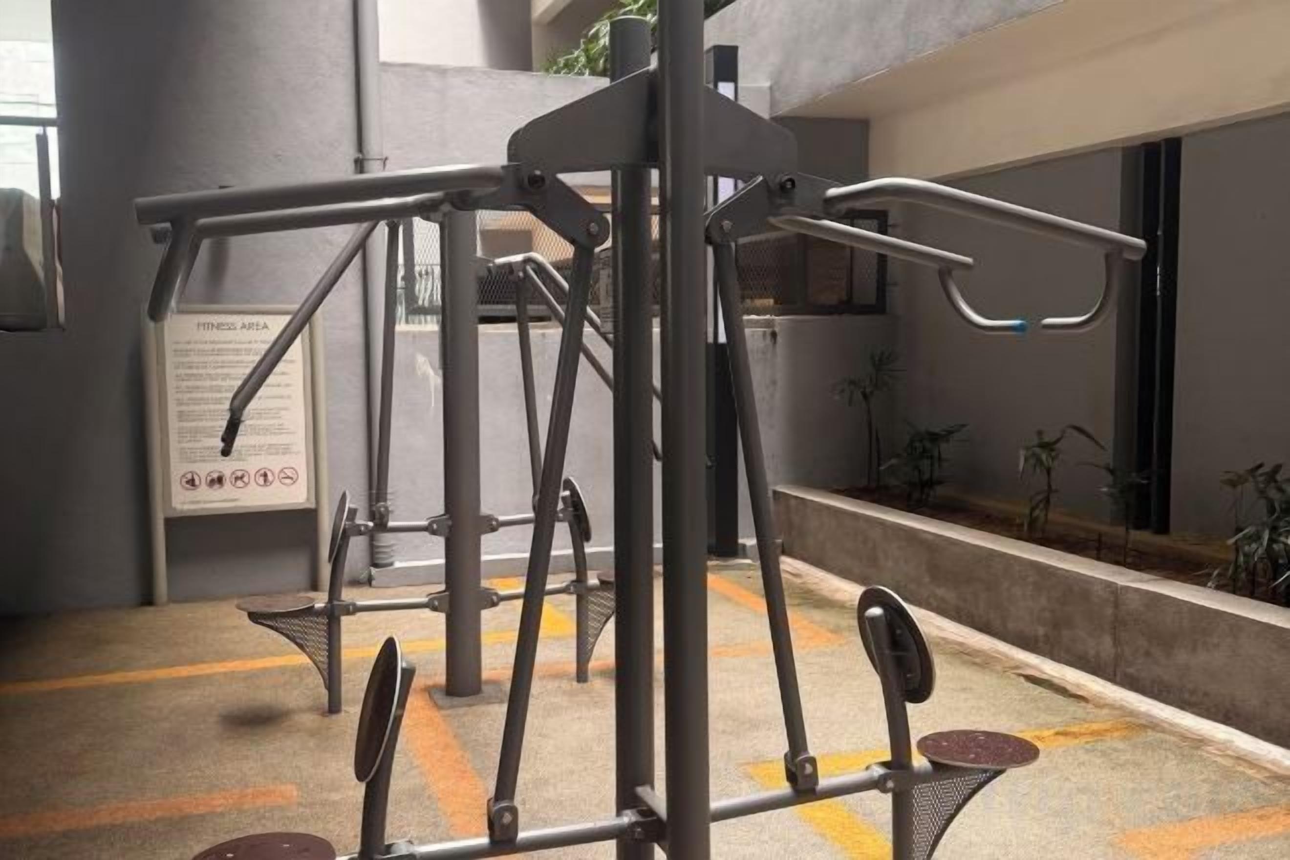 A gym with exercise equipment, a sign with instructions, and a window with plants.