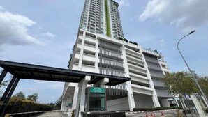 A Marina Residence building with a modern design, featuring a prominent vertical green stripe, a covered entrance, and a sign indicating the name. - Marina Residence 3BR Shores Haven nr Midvalley CIQ (Plentong)