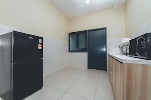 A compact kitchen with a refrigerator, microwave, and a small countertop. - Marina Residence 3BR Shores Haven nr Midvalley CIQ (Plentong)